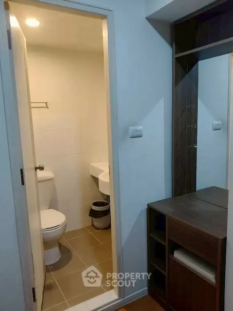 Compact bathroom with modern fixtures and adjacent storage unit