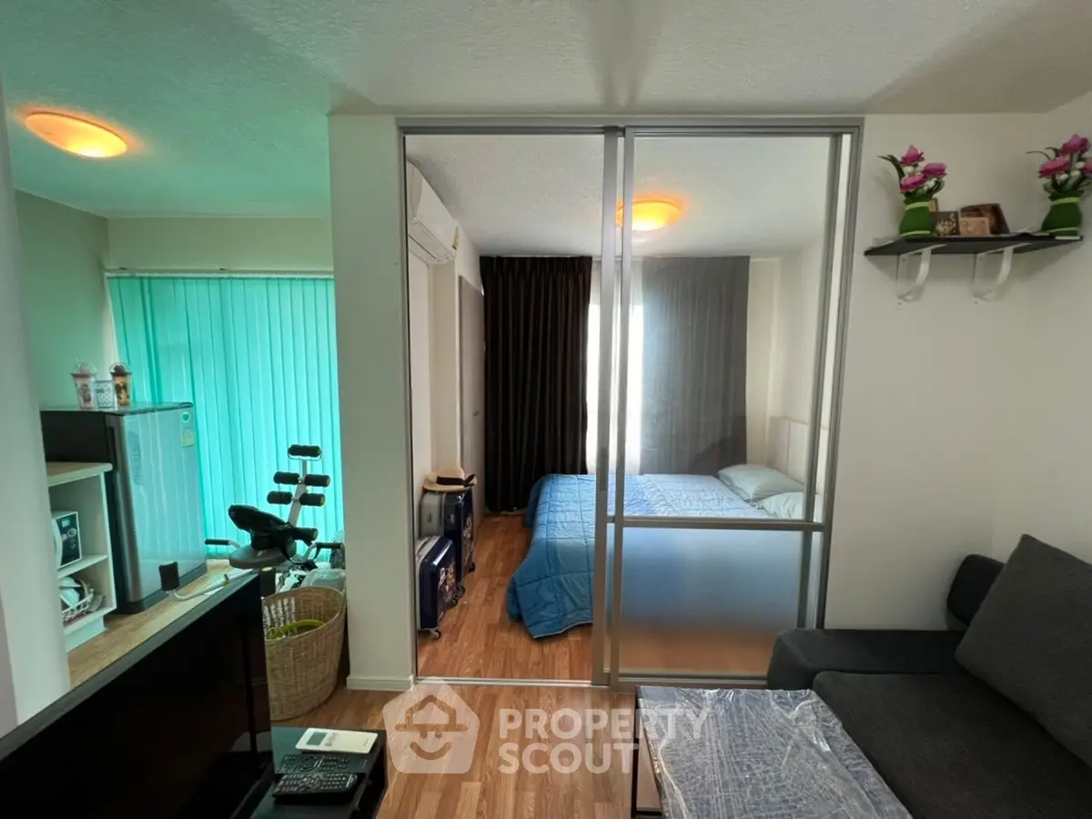 Modern studio apartment with sliding glass partition and cozy living area