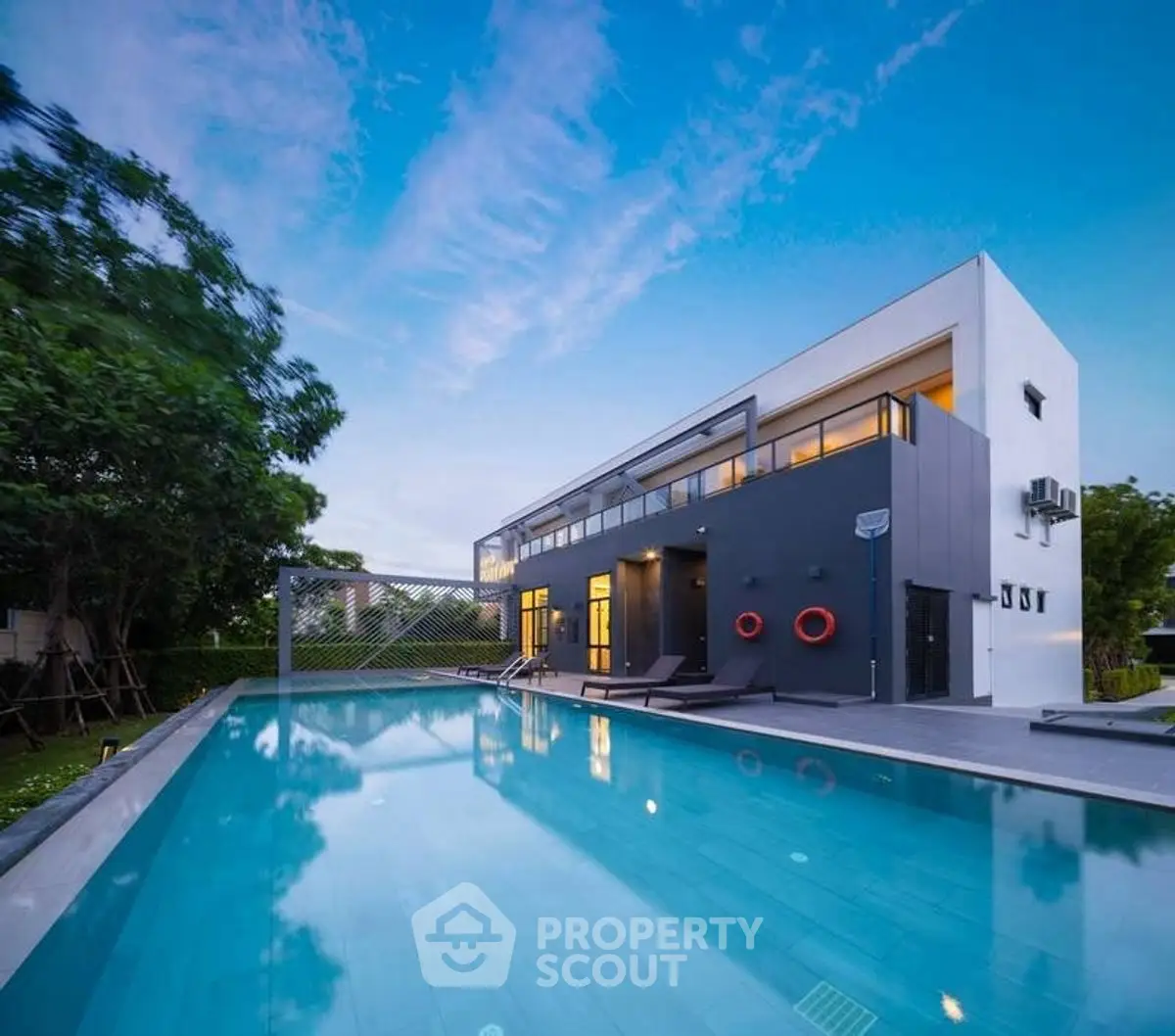 Modern luxury home with sleek design and stunning poolside view at sunset.