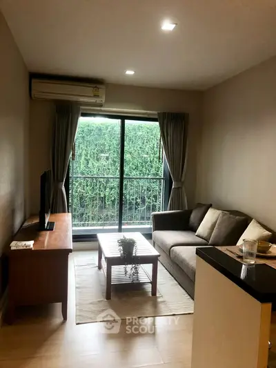 Cozy living room with modern sofa and garden view through large window.