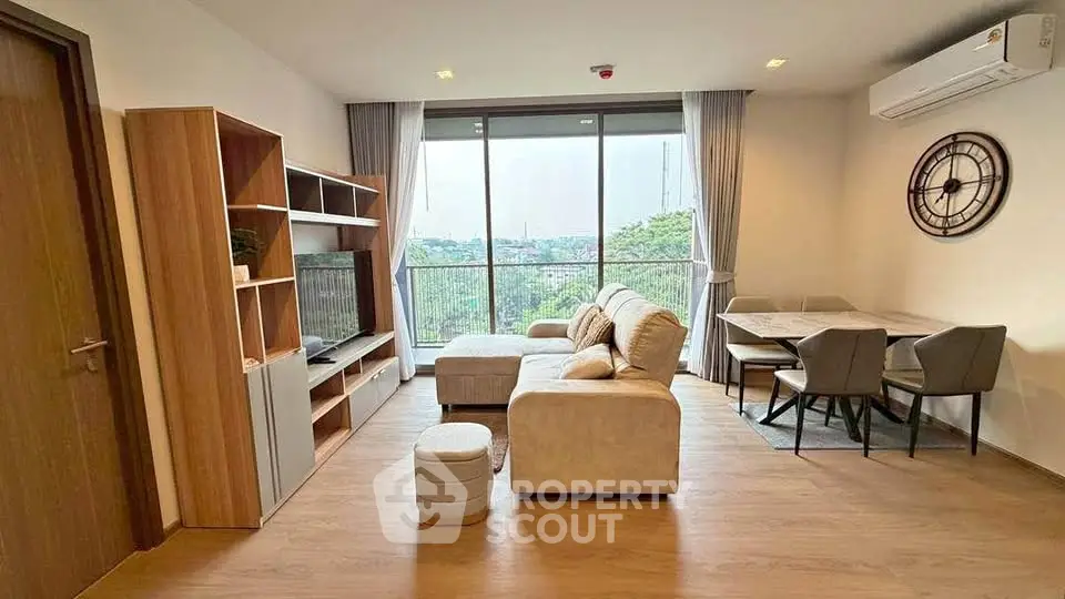 Spacious living room with modern furniture and large window offering a scenic view.