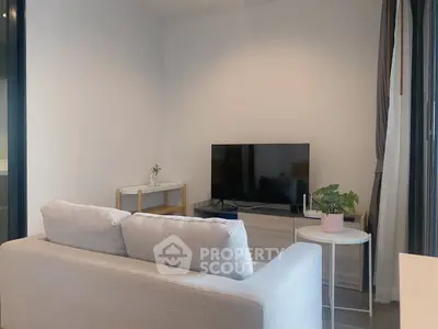 Modern living room with cozy sofa and flat-screen TV, perfect for relaxation.