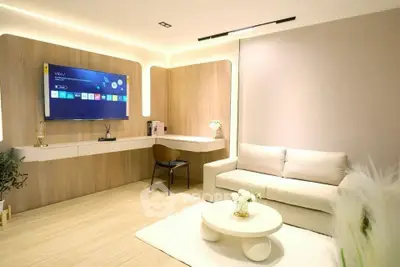 Modern living room with sleek furniture and wall-mounted TV, perfect for relaxation and entertainment.