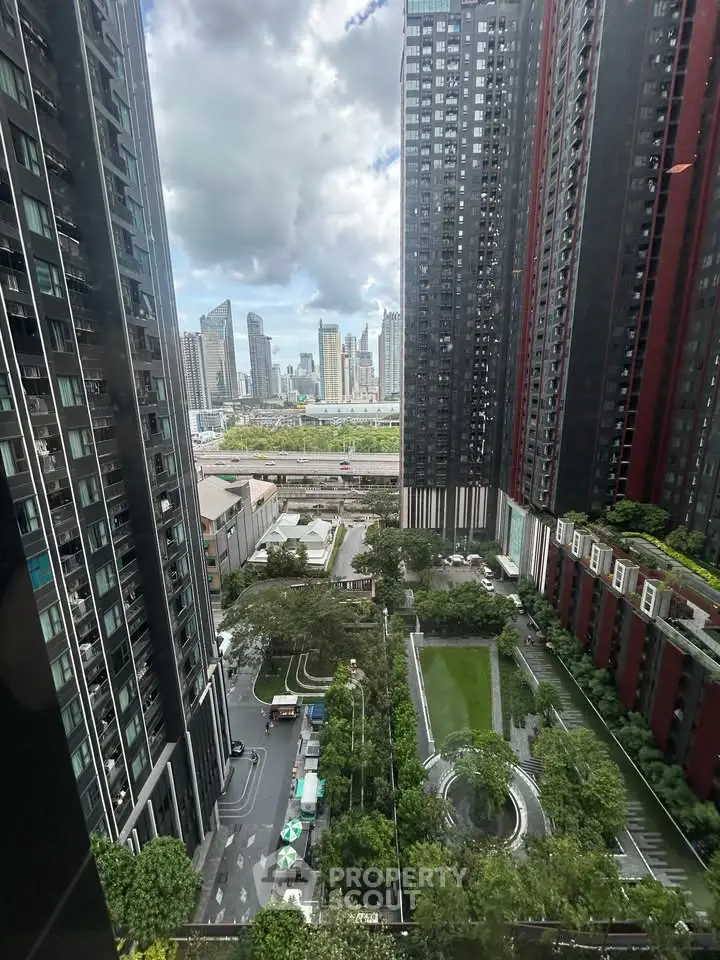 Stunning cityscape view from high-rise building with lush green garden below.