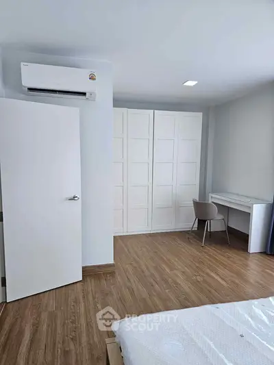 Spacious bedroom with modern air conditioning and elegant wooden flooring