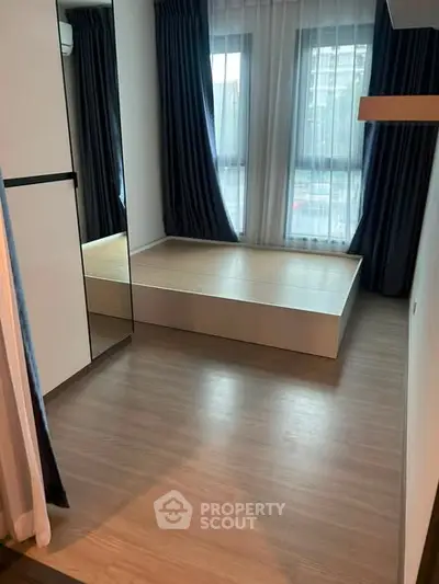 Modern bedroom with minimalist design and large windows for natural light.