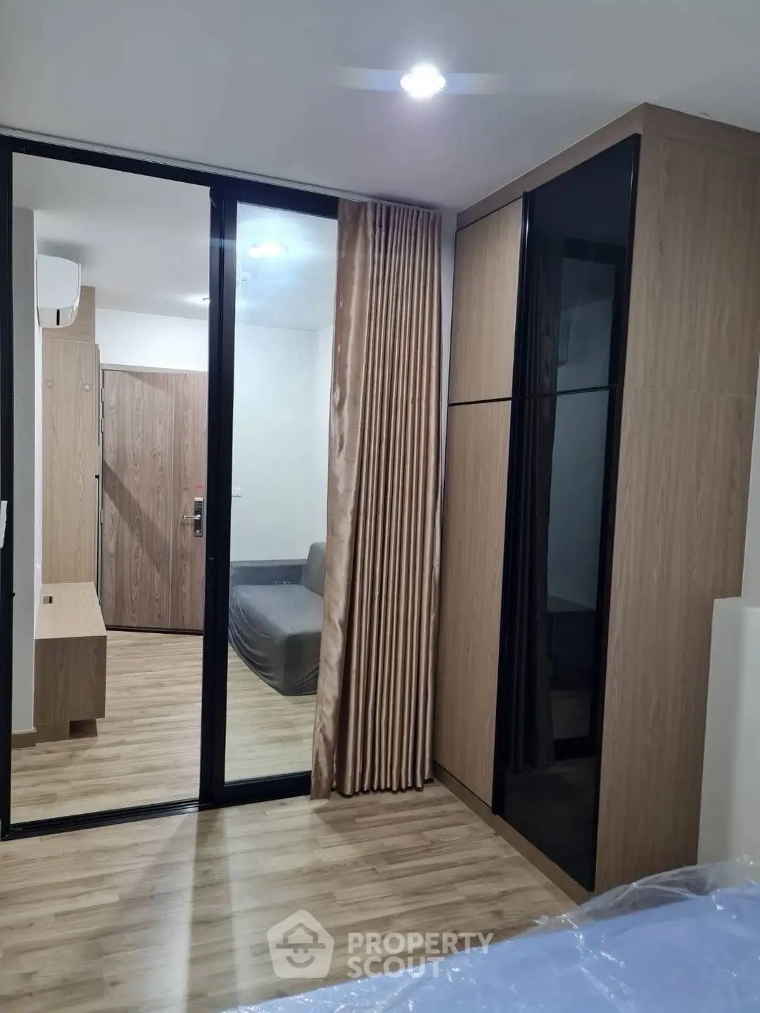 Modern bedroom with sliding glass doors and wooden flooring