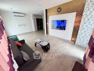 Spacious modern living room with stylish decor and wall-mounted TV, perfect for relaxation and entertainment.