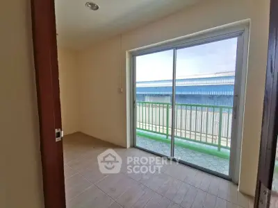 Bright room with sliding glass doors leading to a balcony, offering ample natural light.