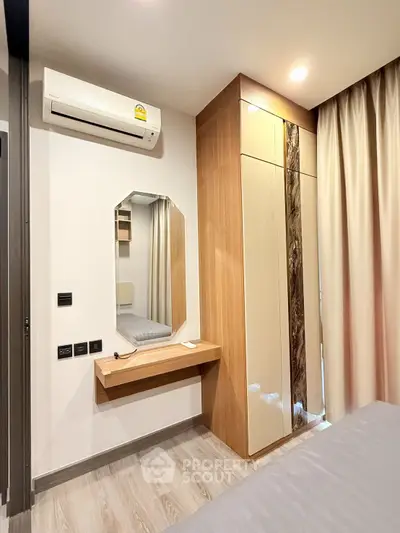 Modern bedroom with sleek wardrobe and air conditioning in a stylish apartment.