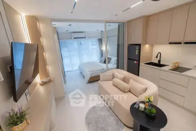 Modern open-plan living room and kitchen with cozy bedroom view