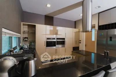 Modern kitchen with sleek appliances and open layout, featuring a built-in oven and stylish countertops.