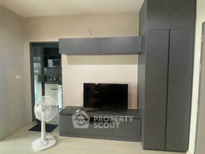 Modern living room with sleek entertainment unit and kitchen view