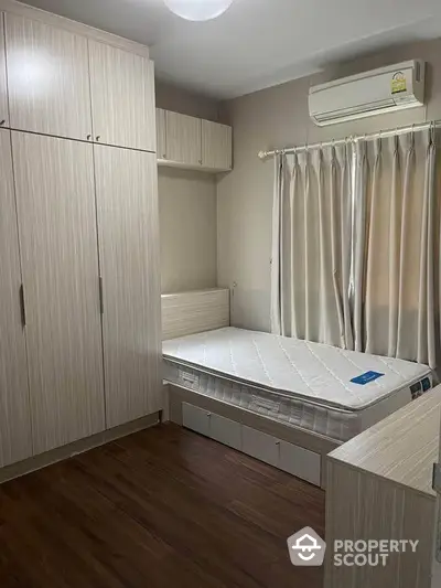 Cozy bedroom with built-in wardrobe and air conditioning, perfect for comfortable living.