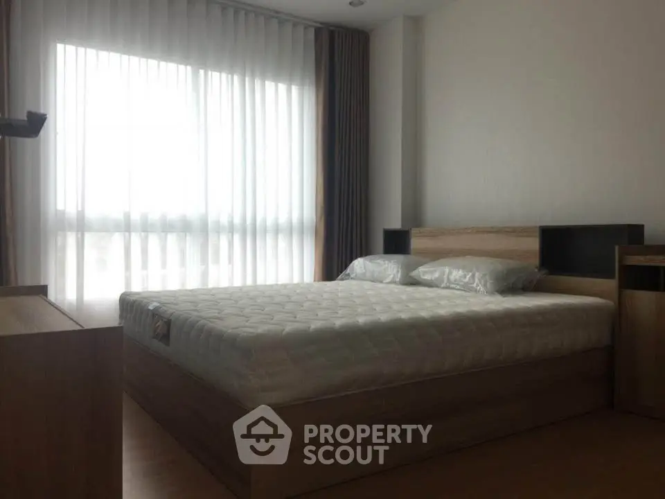 Modern bedroom with large window and stylish wooden furniture