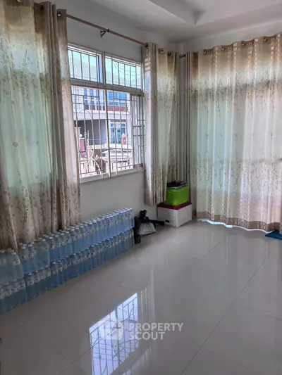 Spacious room with large windows and elegant curtains, perfect for natural light lovers.