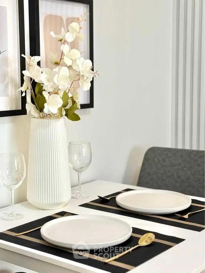 Elegant dining setup with white plates and floral centerpiece in modern home.