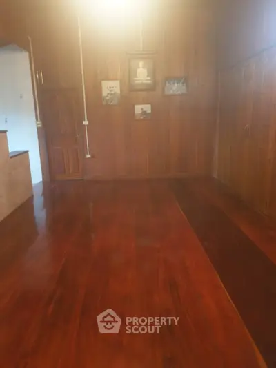 Spacious wooden interior with polished floors and wall art, ideal for cozy living.