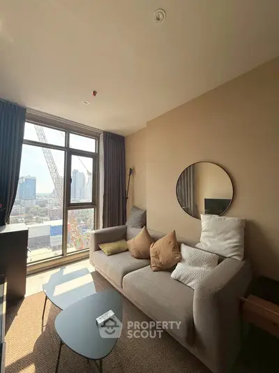 Modern living room with city view, cozy sofa, and stylish decor in high-rise apartment.