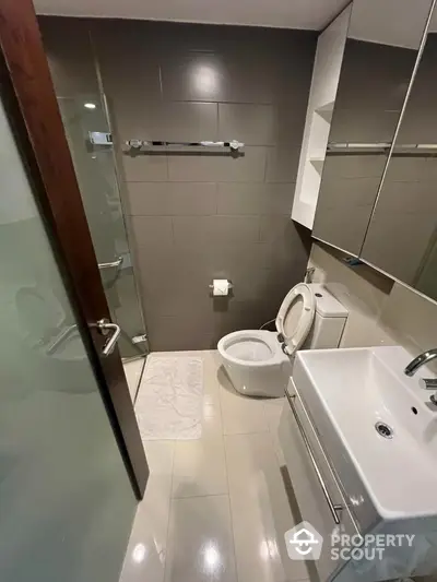 Modern bathroom with sleek fixtures and glass shower in contemporary apartment.