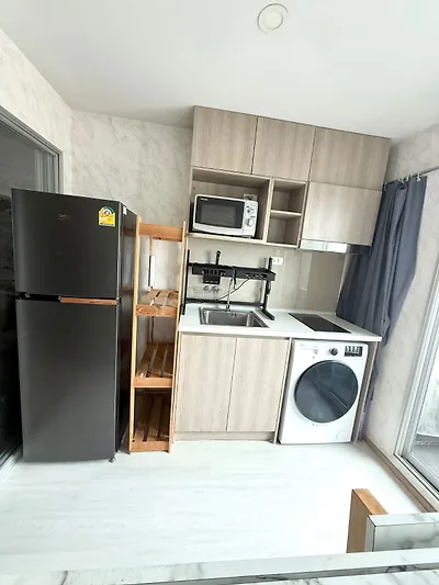 Modern compact kitchen with appliances and sleek cabinetry in a stylish apartment.
