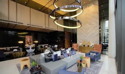 Luxurious modern living room with high ceilings and elegant decor in a sophisticated apartment building.