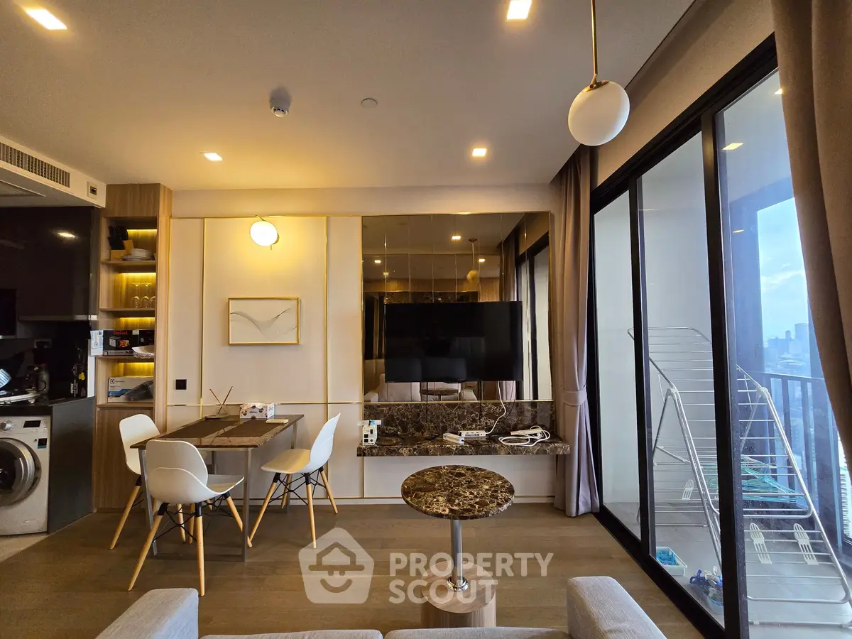 Modern living room with stylish decor and city view balcony, featuring a sleek dining area and wall-mounted TV.