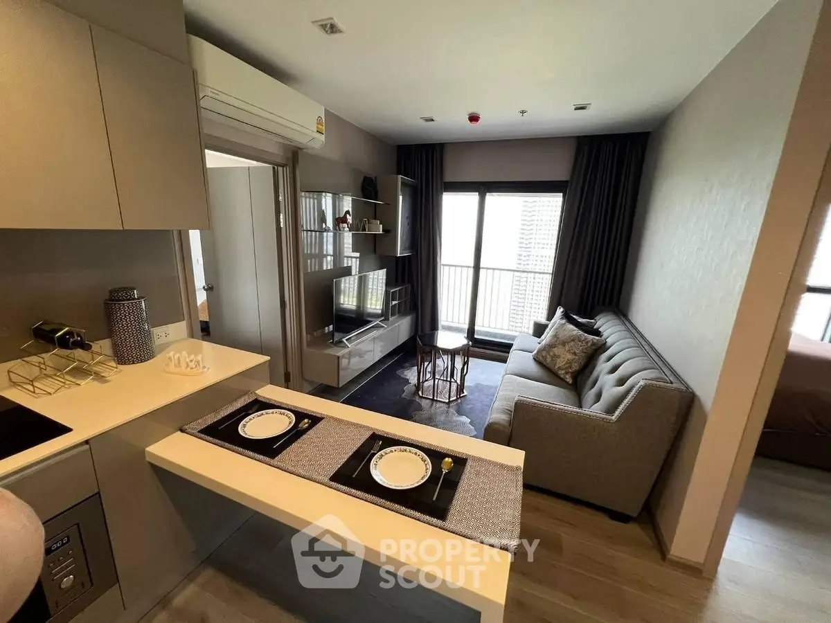 Modern living room with open kitchen and stylish decor in a cozy apartment.