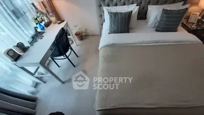 Cozy bedroom with elegant decor and natural light, featuring a stylish desk and comfortable bed.