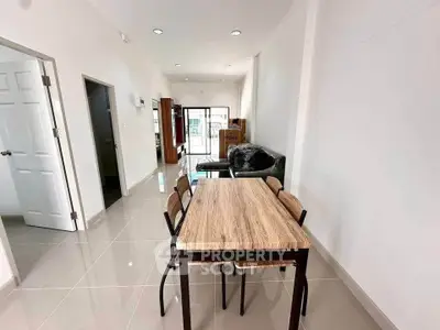 Modern dining area with sleek table and chairs in bright open-plan living space.