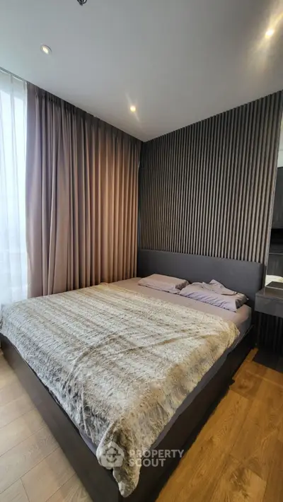Modern bedroom with stylish decor and cozy ambiance, featuring elegant curtains and textured wall design.