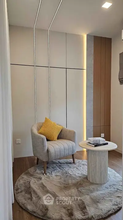 Modern cozy reading nook with stylish armchair and round table in elegant interior design.