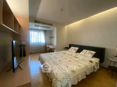 Spacious bedroom with modern decor and natural light in a stylish apartment.
