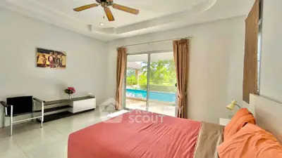 Spacious bedroom with pool view and modern decor, perfect for relaxation.