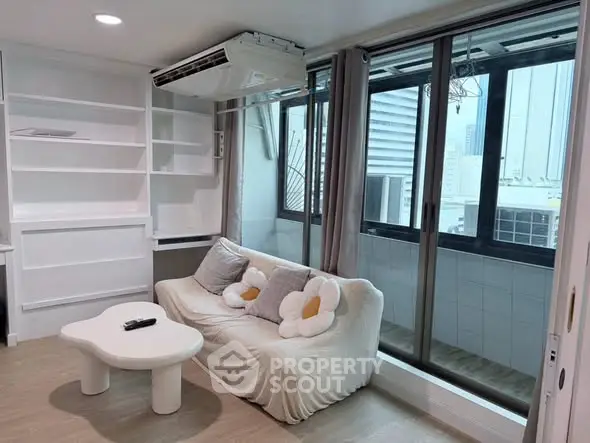 Modern living room with cozy sofa and large windows offering city views, perfect for urban living.