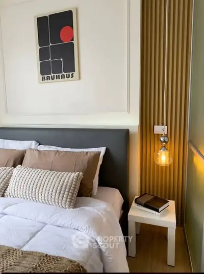 Stylish bedroom with modern decor and cozy lighting, featuring a comfortable bed and chic wall art.