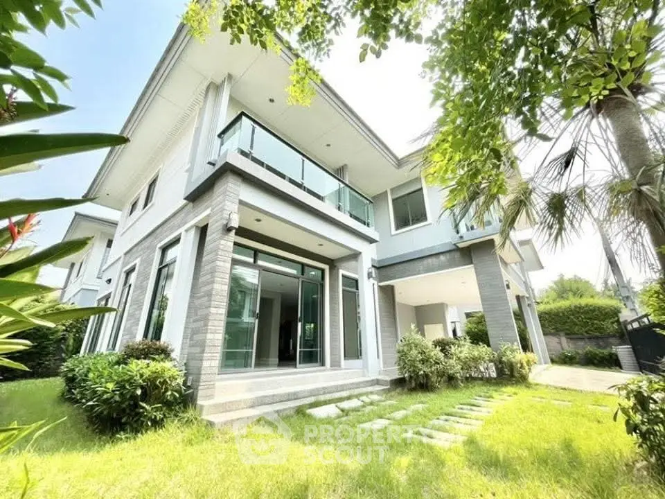 Stunning modern two-story house with lush garden and spacious balcony, perfect for luxurious living.