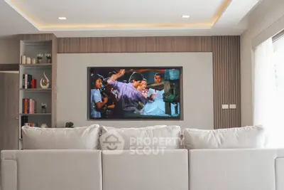 Modern living room with cozy sofa and built-in TV entertainment unit.