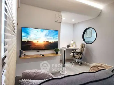 Modern living room with large TV and cozy study nook, perfect for relaxation and productivity.