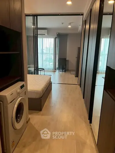 Modern apartment interior with washing machine and bedroom view