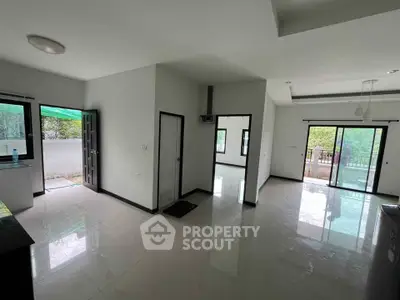 Spacious modern living room with large windows and balcony access, perfect for natural light and outdoor views.