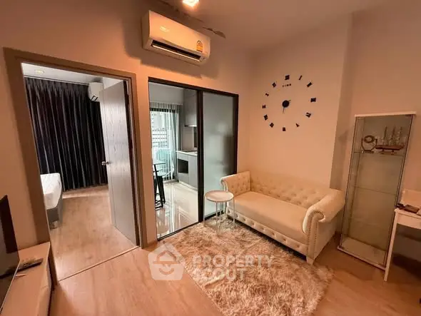 Modern living room with cozy sofa, stylish decor, and open kitchen layout in a chic apartment.