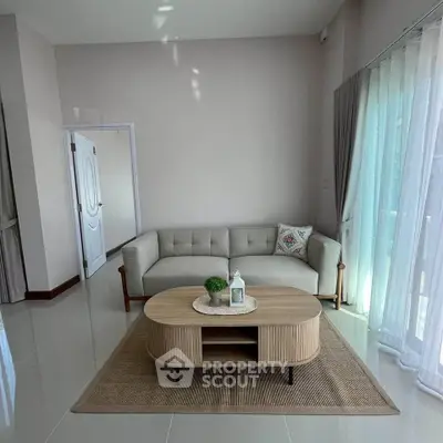 Elegant living room with modern sofa and coffee table, featuring natural light and minimalist decor.