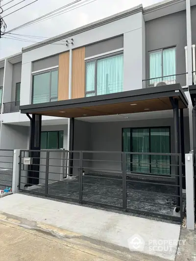 Modern townhouse exterior with sleek design and spacious driveway