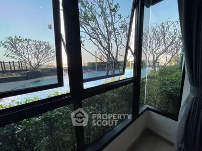 Stunning poolside view from a modern window, showcasing lush greenery and serene outdoor ambiance.