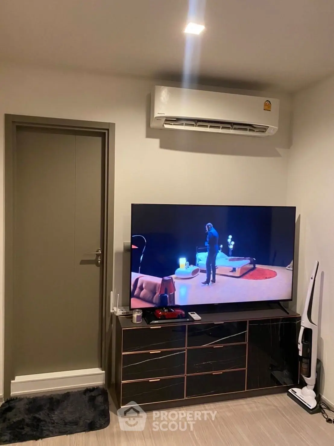 Modern living room with sleek TV setup and air conditioning unit