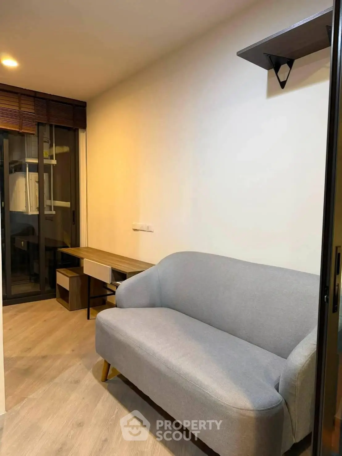 Cozy living room with modern sofa and wooden flooring in a stylish apartment.