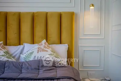 Luxurious bedroom with plush headboard and elegant wall lighting