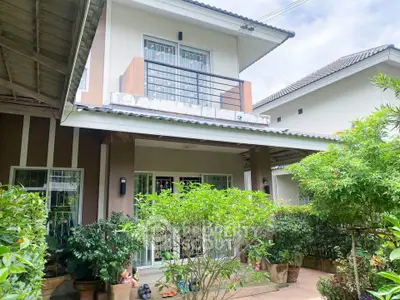 Charming two-story house with lush garden and balcony in a serene neighborhood.