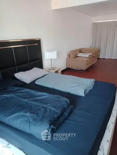 Spacious bedroom with cozy bed and seating area, perfect for relaxation.